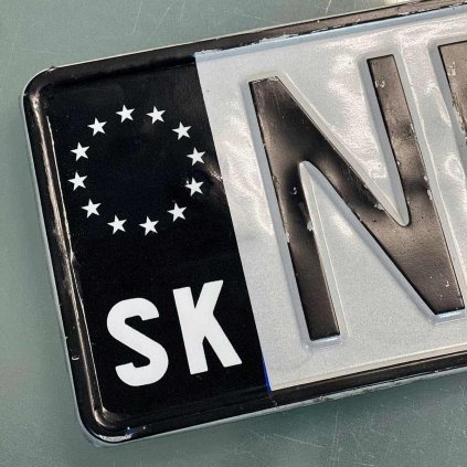 Tabuľka s evidenčným číslom prekrytá čiernou fóliou, ktorá zakrýva pôvodný modrý pruh EÚ s hviezdami a označením „SK“.