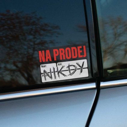 Tlačená nálepka s textom „NA PRODEJ – NIKDY“, paródia na predajnú tabuľku, výrazný nápis a žartovný dizajn.