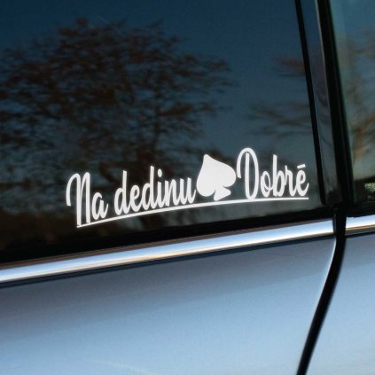 Vtipná biela nálepka s textom "Na dedinu Dobrê" a grafickým prvkom v tvare pikového znaku je umiestnená na zadnom okne auta. Nálepka skvele kontrastuje s tmavým sklom a dodáva autu jedinečný a originálny vzhľad. Ideálna pre tých, ktorí chcú vyjadriť svoj dedinský pôvod alebo vzťah k vidieku s dávkou humoru. Perfektná voľba na personalizáciu vozidla, ktorá určite zaujme okolie.
