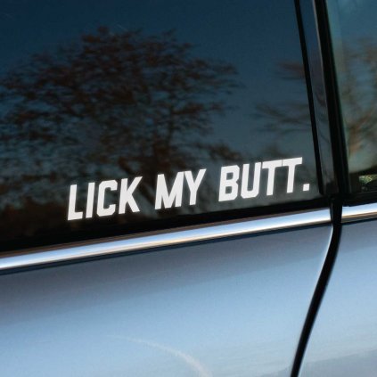 Biela nálepka s textom „Lick My Butt.“ je nalepená na bočnom okne auta. Tento priamy a provokatívny nápis jasne vyjadruje odvážny a drzý postoj majiteľa vozidla. Nálepka je ideálna pre tých, ktorí sa neboja vyjadriť svoj názor, a majú radi výrazné a kontroverzné doplnky na svojom aute. Svojím jednoduchým dizajnom a veľkým, výrazným písmom táto nálepka okamžite upúta pozornosť a určite vyvolá reakcie.