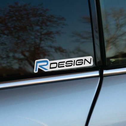 Tlačená nálepka „R DESIGN“ s moderným fontom a výrazným písmenom „R“. Ideálna ako štýlový detail pre vozidlá Volvo R-Design.