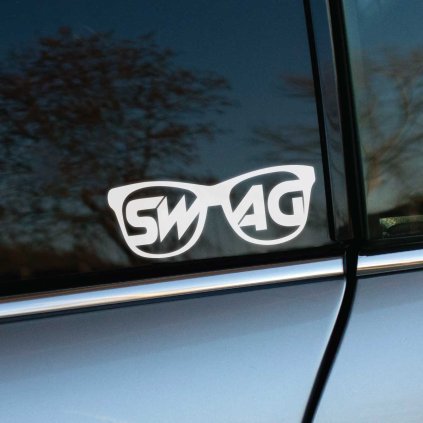 Plotrovaná nálepka v tvare slnečných okuliarov s nápisom „SWAG“ rozdeleným medzi obe sklá v štýlovom písme.