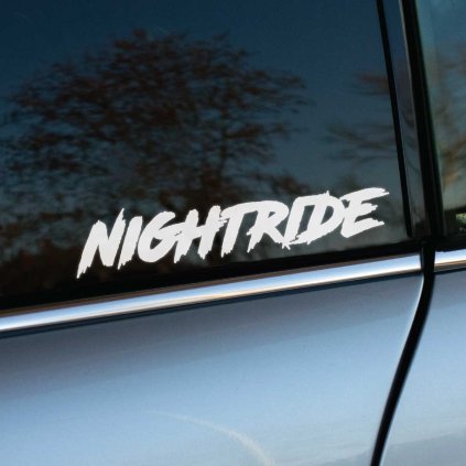 Na fotografii je biela nálepka s nápisom "Nightride" v dynamickom, ručne písanom štýle, nalepená na bočnom okne auta. Tento výrazný dizajn evokuje rýchlosť a adrenalín nočných jázd, čo z nej robí ideálnu nálepku pre nadšencov nočných výletov autom. Nálepka pridáva vozidlu štýlový, moderný vzhľad, ideálny pre tých, ktorí radi jazdia po tme a chcú to vyjadriť originálnym spôsobom.