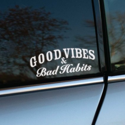 Plotrovaná nálepka textu "Good Vibes & Bad Habits", vtipný a štýlový dvojriadkový motív nálepky na auto s kontrastným písmom.
