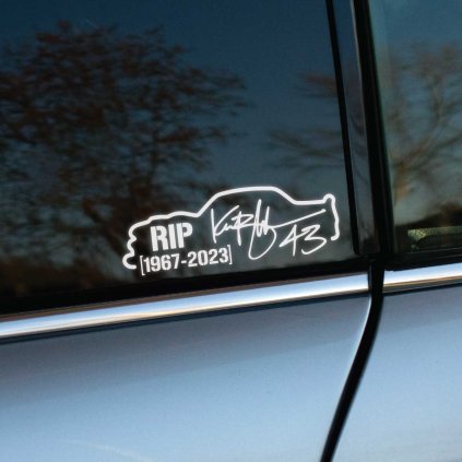 Plotrovaná nálepka na auto s obrysom auta, textom RIP, číslom 43, podpisom a rokmi 1967–2023 ako spomienka na Kena Blocka.