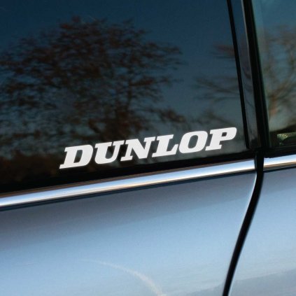 Biela nálepka s logom "Dunlop" na zadnom okne automobilu. Táto nálepka s výrazným a jednoduchým dizajnom je ideálna pre fanúšikov legendárnej značky pneumatík Dunlop. Perfektne sa hodí na akýkoľvek typ auta, pričom zvýrazňuje štýl a podporu kvalitnej značky. Ideálny doplnok pre tuning alebo reklamné účely.  **Kľúčové slová:** nálepka na auto Dunlop, značkové nálepky Dunlop, nálepky na okno auta, reklamné nálepky na auto, tuningové nálepky Dunlop, polepy na auto, dizajn automobilových nálepiek, nálepky na podporu značky pneumatík, kvalitné nálepky na auto, doplnky na auto Dunlop.
