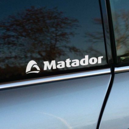 Biela nálepka s logom "Matador" a ikonickým grafickým symbolom na zadnom okne automobilu. Táto nálepka je skvelým spôsobom, ako reprezentovať známeho výrobcu pneumatík a dodať vozidlu osobitý štýl. Minimalistický dizajn a kvalitné prevedenie zaručujú, že nálepka bude výborne vynikať na každom aute, čím osloví všetkých milovníkov značky Matador.  **Kľúčové slová:** nálepka na auto Matador, značkové nálepky Matador, reklamné nálepky na auto, nálepky na okno auta, polepy na auto Matador, tuningové nálepky, nálepky pneumatík, dizajn automobilových nálepiek, kvalitné nálepky na auto, doplnky na auto Matador.