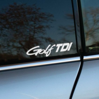 Plotrovaná nálepka s nápisom „Golf TDI“ v dynamickom a technickom písme na bočné okno auta.