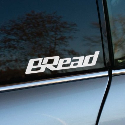 Na fotografii je biela nálepka s nápisom „BRead“ nalepená na bočnom okne auta. Tento dizajn v štýlovom a dynamickom písme pripomína logá automobilových značiek a dielov, no s vtipnou hrou so slovom „Bread“, čo znamená chlieb. Nálepka je ideálnym doplnkom pre tých, ktorí chcú pridať svojmu autu originálny a zábavný prvok, pričom môže zaujať najmä automobilových nadšencov so zmyslom pre humor.