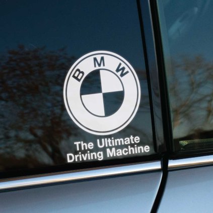 Plotrovaná nálepka na auto s logom BMW a sloganom The Ultimate Driving Machine, štýlový doplnok pre fanúšikov značky.