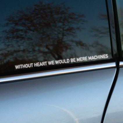 Plotrovaná nálepka s citátom v bezpätkovom písme s presným znením WITHOUT HEART WE WOULD BE MERE MACHINES.