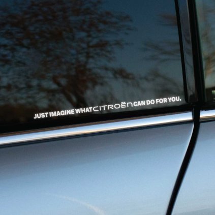 Plotrovaná nálepka tvorená jedným riadkom s textom JUST IMAGINE WHAT CITROËN CAN DO FOR YOU písaným paličkovým písmom.