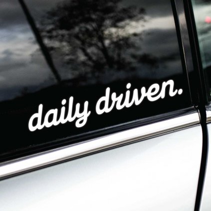 Biela nálepka s nápisom "daily driven." nalepená na okne bieleho auta. Táto nálepka s jednoduchým a čistým dizajnom vyjadruje, že auto je využívané každý deň. Ideálny doplnok pre vodičov, ktorí chcú zdôrazniť svoju vášeň pre jazdu a pravidelné využívanie svojho vozidla. Štýlový detail, ktorý pridáva osobitosť a zvýrazňuje praktickosť majiteľa auta.