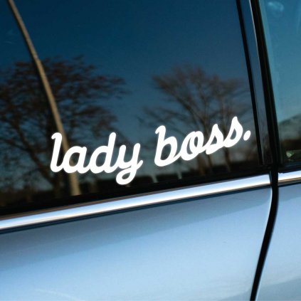 Biela nálepka s nápisom "lady boss." nalepená na bočnom okne strieborného auta. Moderný a elegantný dizajn nálepky vyjadruje sebadôveru a nezávislosť ženy, ktorá ju vlastní. Perfektný doplnok pre auto, ktorý zvýrazní individualitu a osobný štýl. Skvelá voľba pre každú sebavedomú ženu, ktorá chce ozdobiť svoje vozidlo originálnym spôsobom.