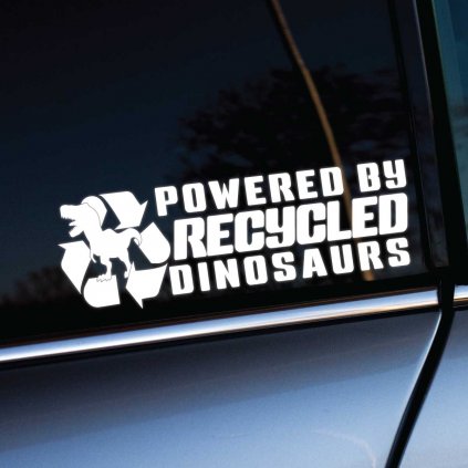 Vtipná biela nálepka na auto s textom "Powered by Recycled Dinosaurs" a siluetou dinosaura v recyklačnom symbole. Nálepka je pripevnená na okno auta, kde vyniká kontrastným dizajnom, ktorý okamžite upúta pozornosť. Ideálna pre milovníkov humoru a fanúšikov tematických nálepiek na automobil, ktoré zvýraznia osobnosť majiteľa. Perfektný doplnok pre každé auto, ktorý pridáva dávku originality a šarmu.