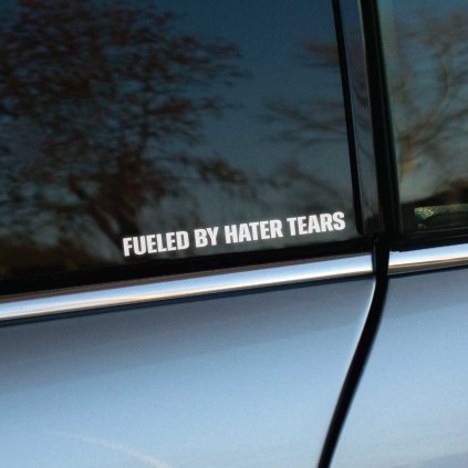 Plotrovaná nálepka Fueled by Hater Tears s jednoduchým horizontálnym nápisom, decentná a dobre čitateľná z diaľky.