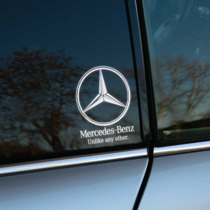 Na fotografii je zobrazené okno auta Mercedes-Benz s nalepenou nálepkou, ktorá obsahuje logo značky a slogan "Unlike any other." Táto nálepka elegantne zvýrazňuje prestíž a jedinečnosť vozidla, pričom biele logo na tmavom pozadí dodáva štýlový kontrast. Ideálny doplnok pre tých, ktorí chcú podčiarknuť výnimočnosť svojho Mercedesu a odlíšiť sa od ostatných.