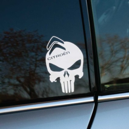Na obrázku vidíme bielu nálepku na zadnom okne auta, ktorá zobrazuje lebku s výrazom odhodlania, nad ktorou sa nachádza logo značky Citroën. Táto originálna nálepka kombinuje ikonický symbol lebky s dvojitou šípkou charakteristickou pre Citroën, čo vytvára jedinečný a dynamický vzhľad. Je ideálnym doplnkom pre majiteľov vozidiel Citroën, ktorí chcú svojmu autu pridať osobitý štýl a vyniknúť na cestách.