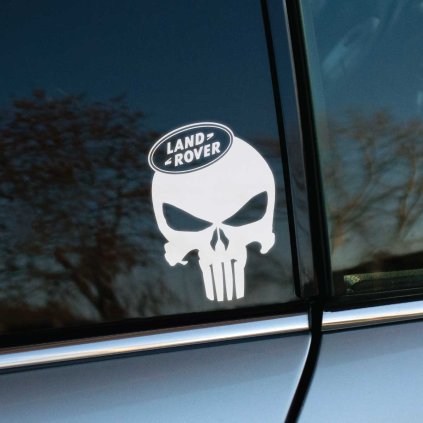 Biela Punisher lebka s logom Land Rover na vrchu, nalepená na bočnom okne auta. Táto nálepka spája ikonický symbol Punishera s robustným a dobrodružným duchom značky Land Rover, čím vozidlu dodáva nekompromisný a výrazný vzhľad. Ideálny doplnok pre majiteľov Land Rover, ktorí chcú vyjadriť svoj drsný štýl a pripravenosť čeliť akýmkoľvek výzvam prostredníctvom originálnej auto nálepky.