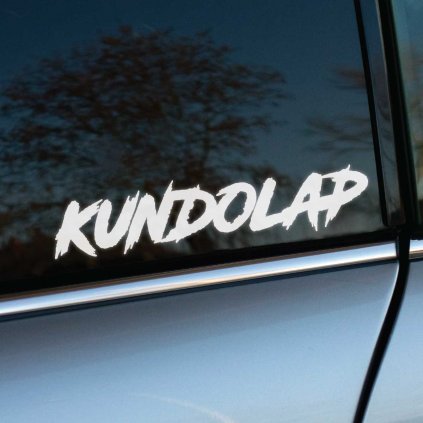 Na fotografii je výrazná biela nálepka s nápisom "Kundolap" v dynamickom, ručne písanom štýle, ktorá pôsobí energicky a odvážne. Nálepka je nalepená na zadnom okne sivého auta, čo vytvára silný kontrast medzi bielym textom a tmavým sklom. Tento dizajn je ideálny pre tých, ktorí chcú svojmu autu dodať nápadný a drsný vzhľad, a zároveň pobaviť okoloidúcich. Perfektný spôsob, ako oživiť vozidlo a vyjadriť svoju osobitosť.