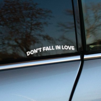 Plotrovaná nálepka Don't Fall In Love v mierne zakrivenom prevedení, ideálna pre minimalistický vzhľad auta.