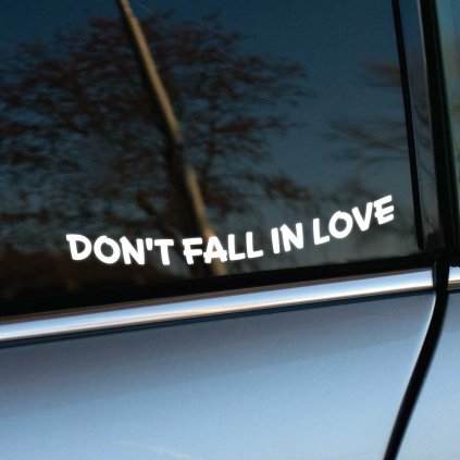Plotrovaná nálepka Don't Fall In Love s jednoduchým textom v miernom oblúku, decentná voľba s jemným odkazom.
