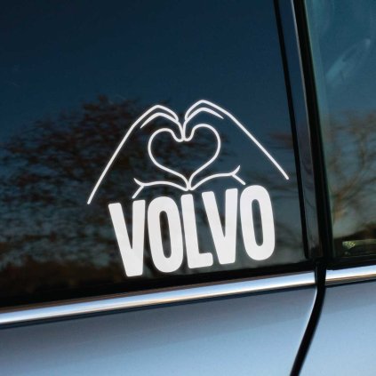 Štýlová nálepka na zadnom okne automobilu značky Volvo zobrazuje ruky formujúce tvar srdca. Tento biely, moderný dizajn vyniká na tmavom pozadí skla, čím dodáva vozidlu jedinečný a osobný dotyk. Perfektný doplnok pre majiteľov áut Volvo, ktorí chcú vyjadriť svoju lásku k tejto značke a zároveň hľadajú kreatívne a estetické dekorácie na svoje vozidlo. Ideálna voľba pre milovníkov áut, ktorí túžia ozdobiť svoje auto štýlovým a jedinečným prvkom.