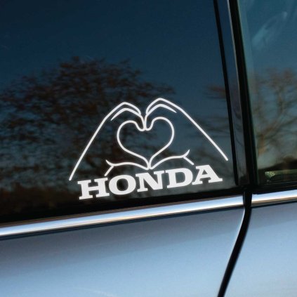 Na obrázku je nálepka na bočnom okne auta Honda. Dve ruky formujúce srdce sú umiestnené nad nápisom "HONDA", čo dodáva tejto nálepke jedinečný a osobný vzhľad. Tento kreatívny dizajn je ideálny pre všetkých majiteľov a fanúšikov značky Honda, ktorí chcú svojmu vozidlu pridať špeciálny dotyk. Nálepka nielen zlepšuje estetiku auta, ale tiež vyjadruje vašu lásku k tejto spoľahlivej a populárnej automobilovej značke. Perfektný doplnok pre každého, kto chce prejaviť svoju vášeň pre Hondy a spraviť svoje vozidlo výnimočným.