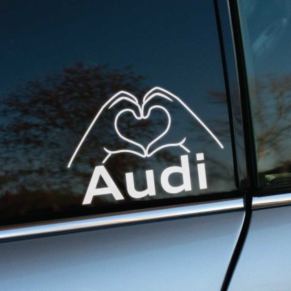 Plotrovaná nálepka s nápisom Audi a motívom rúk formujúcich srdce, jednoduchý a štýlový dizajn pre fanúšikov značky.