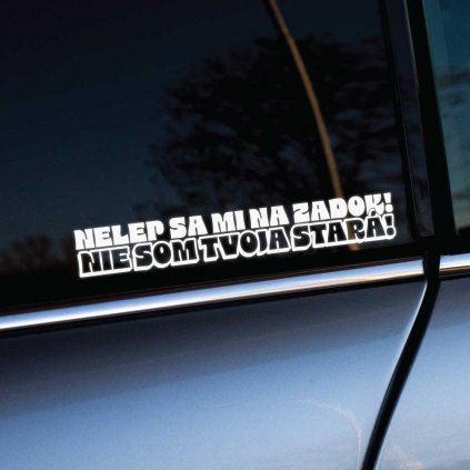 Vtipná nálepka na aute s textom „Nelep sa mi na zadok! Nie som tvoja stará!“ v hrubom bielom písme, nalepená na zadnom bočnom okne strieborného vozidla. Tento dizajn s humorom upozorňuje ostatných vodičov, aby dodržiavali bezpečnú vzdialenosť, a dodáva vozidlu štipku osobitosti a zábavy. Skvelý doplnok pre tých, ktorí majú radi originálne a drzé nálepky na autách.