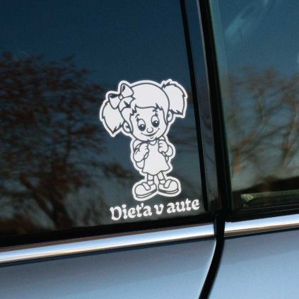 Plotrovaná nálepka s ilustráciou usmievavej školáčky s ruksakom a dvoma copmi ozdobenými mašľou. Pod postavou sa nachádza nápis Dieťa v aute v oblom a tučnom type písma.