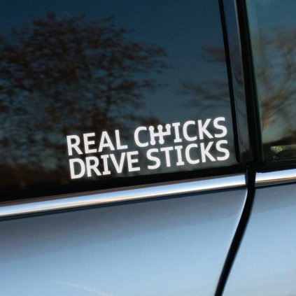 Plotrovaná nálepka na auto s textom „REAL CHICKS DRIVE STICKS“ a ikonickým symbolom manuálnej radiacej páky.
