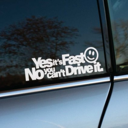 Na fotografii je biela nálepka s vtipným nápisom „Yes it’s Fast 😊 No you can’t Drive it“ a smajlíkom, nalepená na okne auta. Nálepka je umiestnená na časti sivého alebo strieborného vozidla a jej text okamžite zaujme svojou humornou provokáciou. Ide o ideálny doplnok pre majiteľov rýchlych a upravených áut, ktorí chcú na cestách vyjadriť svoju hrdosť na výkon svojho vozidla a zároveň odpovedať na prípadné otázky okoloidúcich. Táto nálepka dodáva autu osobitý charakter a zmysel pre humor.