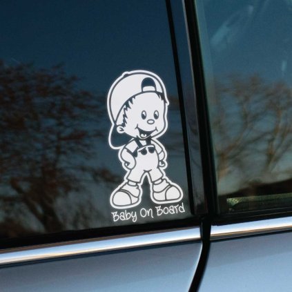 Plotrovaná nálepka s kreslenou postavičkou chlapca v šiltovke, ktorý má ruky v bok. Pod ním je rovný text Baby On Board.