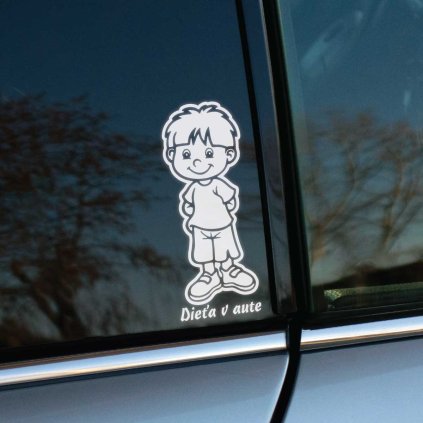 Plotrovaná nálepka, usmievavý stojaci chlapec v tričku a šortkách s rukami vo vreckách a slovenský nápis Dieťa v aute pod ním.