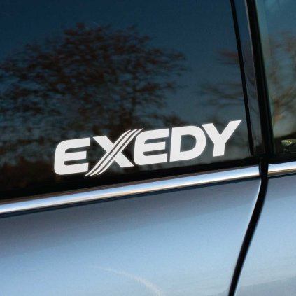 Biela nálepka s logom „EXEDY“, ktoré je známe vo svete motoršportu a automobilových spojok, je elegantne umiestnená na bočnom okne auta. Charakteristický dizajn s dynamickými líniami v písmene „X“ symbolizuje výkon, precíznosť a technologickú dokonalosť. Táto nálepka je ideálna pre milovníkov tuningu a kvalitných autodoplnkov, ktorí chcú svojmu vozidlu dodať športový a profesionálny vzhľad. Výrazný kontrast na tmavom skle zaisťuje, že nálepka upúta pozornosť. Odolné prevedenie zabezpečuje jej trvácnosť aj pri nepriaznivých podmienkach.    **Kľúčové slová:** nálepka na auto, EXEDY logo, biela nálepka, tuning auta, športový dizajn, autodoplnky, nálepky na vozidlo, kvalitné nálepky, nálepky na okno auta, personalizácia auta, motoršport, vysokovýkonné spojky, moderný vzhľad auta, pretekársky štýl, dynamický dizajn.