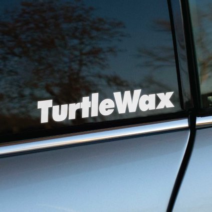 Biela nálepka "TurtleWax" na zadnom bočnom okne strieborno-sivého auta. Jednoduché, čisté písmo nálepky symbolizuje spoľahlivosť a starostlivosť o vozidlo, pričom vyniká na tmavom tónovanom skle. Ideálne pre fanúšikov autokozmetiky a profesionálnej starostlivosti o automobily.  **Kľúčové slová:** nálepka na auto, samolepka TurtleWax, tuningová nálepka, logo TurtleWax, nálepka na sklo auta, auto dekorácia, automobilové nálepky, personalizácia auta, štýlové nálepky, doplnky na auto.
