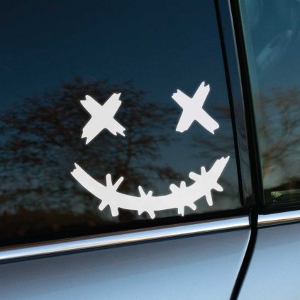 Plotrovaná nálepka na auto so stylizovanou tvárou s preškrtnutými očami a úsmevom z ostnatého drôtu v kreslenom štýle.