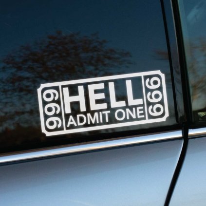 Fotografia zobrazuje nálepku v tvare vstupenky s nápisom "HELL ADMIT ONE" a číslom "666" na oboch stranách. Nálepka je nalepená na bočnom okne auta a je bielej farby, čo výrazne kontrastuje s tmavým sklom okna. Text je umiestnený v strede nálepky s veľkým slovom "HELL" a menším textom "ADMIT ONE" pod ním. Nálepka má dizajn pripomínajúci klasickú vstupenku s vystrihnutými rohmi. V pozadí sú viditeľné stromy a modrá obloha, ktoré sa odrážajú na skle. Fotografia je pravdepodobne urobená vonku za denného svetla.