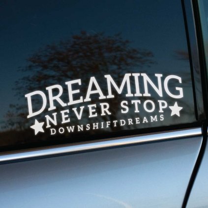 Plotrovaná nálepka Dreaming Never Stop Downshiftdreams so zvýrazneným sloganom, ideálna pre fanúšikov snového jazdenia.
