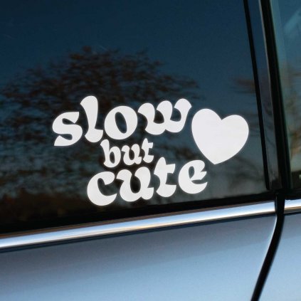 Plotrovaná nálepka na auto s nápisom „slow but cute“ v retro písme a motívom srdca ako hravým doplnkom.