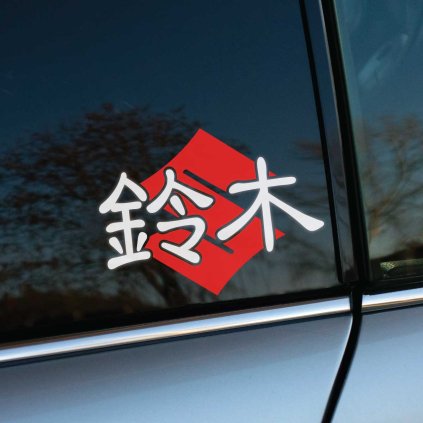 Štýlová nálepka na auto s japonskými znakmi 鈴木 (Suzuki) na červenom pozadí, umiestnená na zadnom okne šedého automobilu. Táto výrazná dekorácia nielenže podčiarkne vašu vášeň pre značku Suzuki, ale tiež pridá vášmu vozidlu jedinečný a dynamický vzhľad. Vyberte si kvalitné auto nálepky pre váš Suzuki a dodajte mu osobitý štýl.