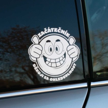 Plotrovaná nálepka so smajlíkom, zdvihnutými palcami a textom „Začátečník – Děkuji za ohleduplnost.“ Ideálna pre nových vodičov na auto.