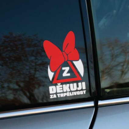 Plotrovaná nálepka so symbolom začiatočníka „Z“ v trojuholníku, doplnená o červenú mašľu a text „Děkuji za trpělivost“.