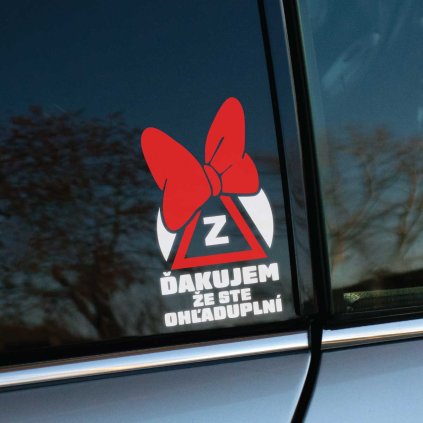 Plotrovaná nálepka so symbolom začiatočníka „Z“ v trojuholníku, červenou mašľou a textom „Ďakujem, že ste ohľaduplní“.