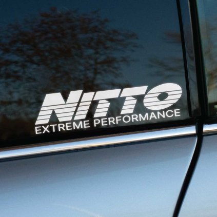 Plotrovaná nálepka s logom NITTO a nápisom EXTREME PERFORMANCE, s horizontálnymi linkami v písmenách.