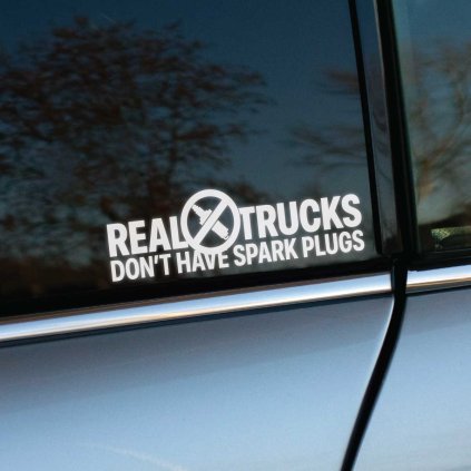 Plotrovaná nálepka s nápisom „Real trucks don’t have spark plugs“ a preškrtnutou sviečkou, vtipná nálepka na auto pre diesel fanúšikov.