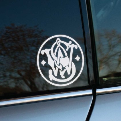 Plotrovaná nálepka na auto s emblémom Smith & Wesson, prepletené iniciály v kruhovom ráme doplnené ozdobnými hviezdami.