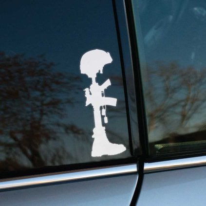 Plotrovaná nálepka na auto so siluetou vojenského pamätníka zloženého z pušky, helmy, topánky a identifikačných známok.