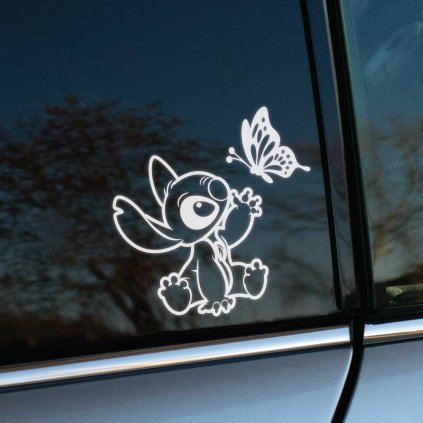 Plotrovaná nálepka na auto s postavičkou Stitch, ako sedí a naťahuje sa za motýľom, v milom kreslenom dizajne.